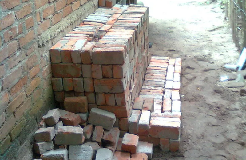 Red building bricks stacked beside masonry
