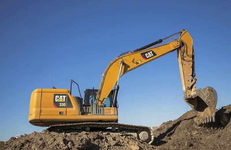 Tracked excavator working on a pile of earth