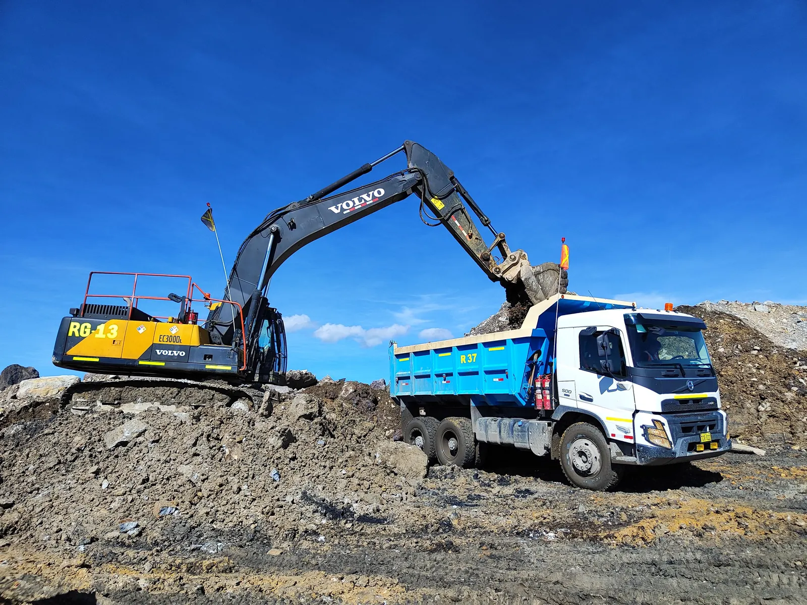 Excavator loading earth into a tipper truck at a construction site